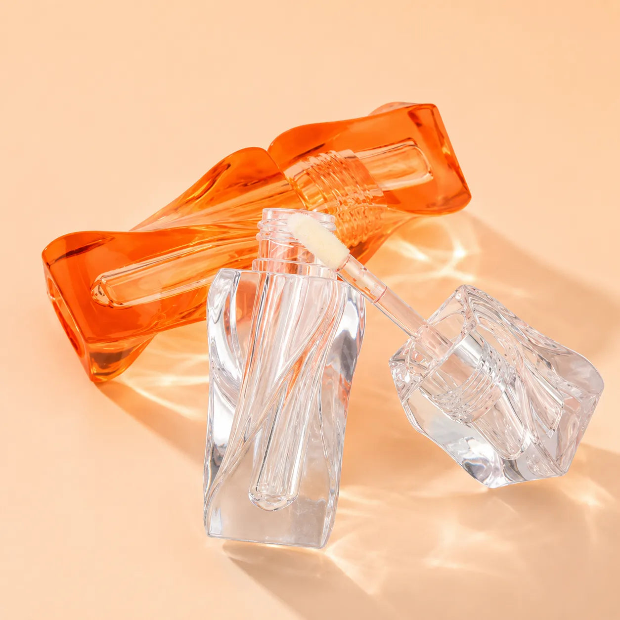 Kaiya clear lip gloss tube with wavy shape, custom color design, and transparent applicator packaging