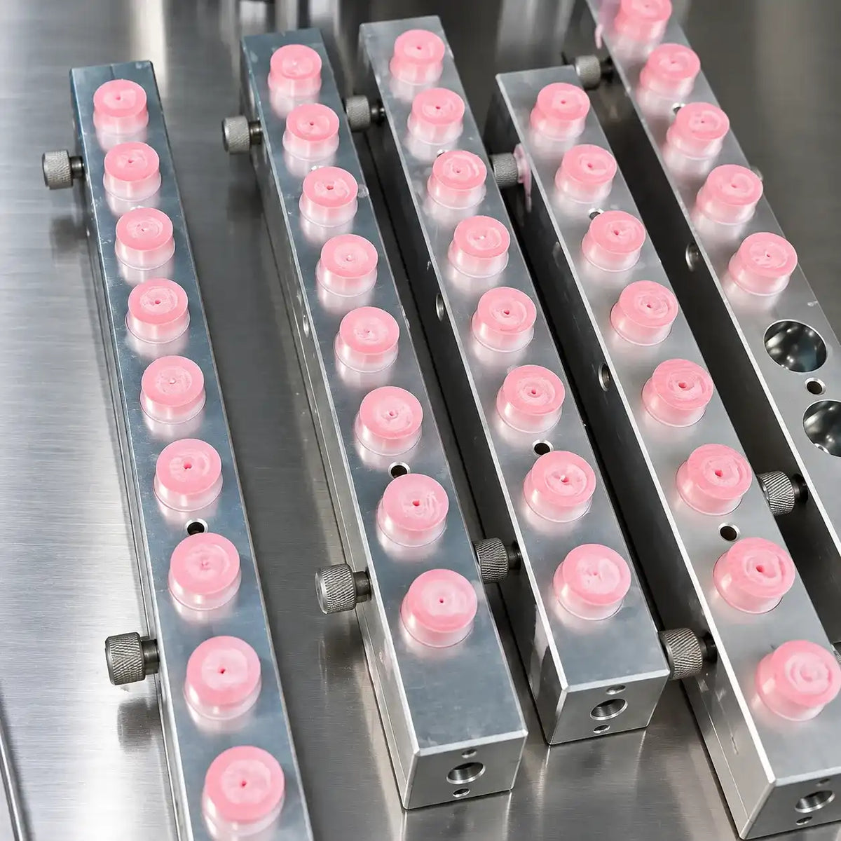Highlighter mold-filling production at KAIYA, showing multiple pink cosmetic products arranged in precision metal molds for manufacturing.