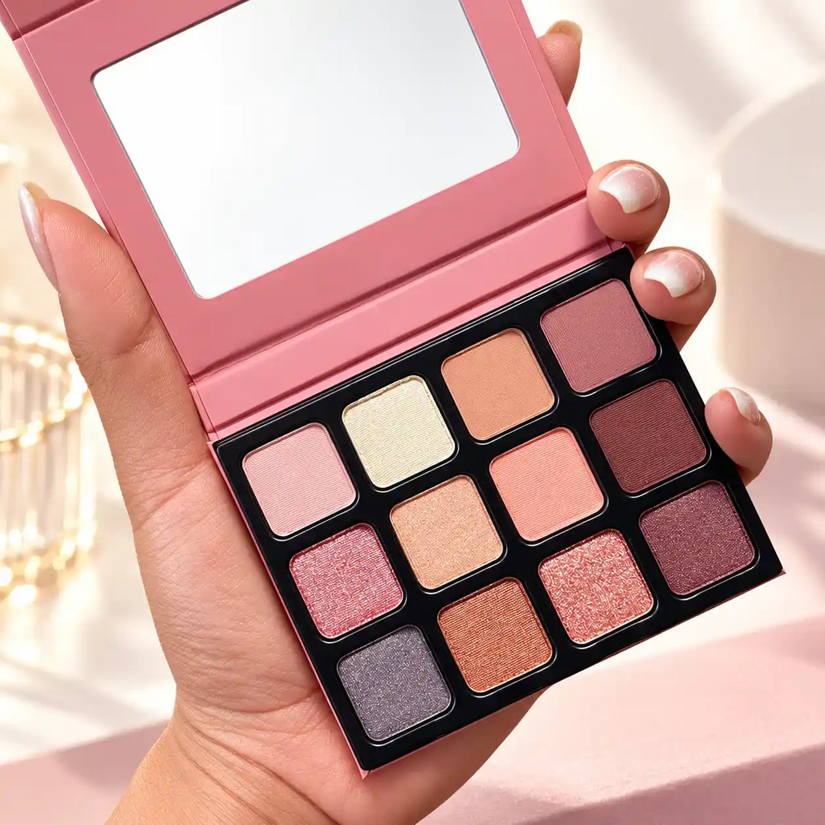 KAIYA custom eyeshadow palette with 12 pans in a pink mirrored case, combining neutral, rose and deeper shades.