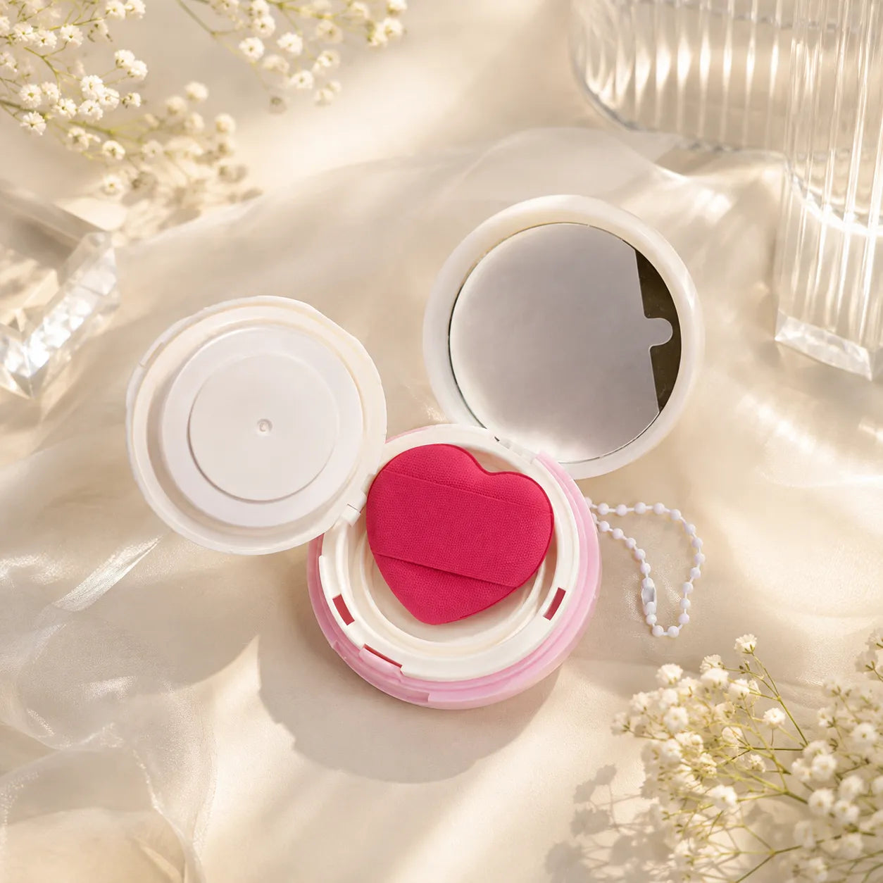 Empty cushion compact with heart-shaped puff and mirror for custom cosmetic packaging projects.