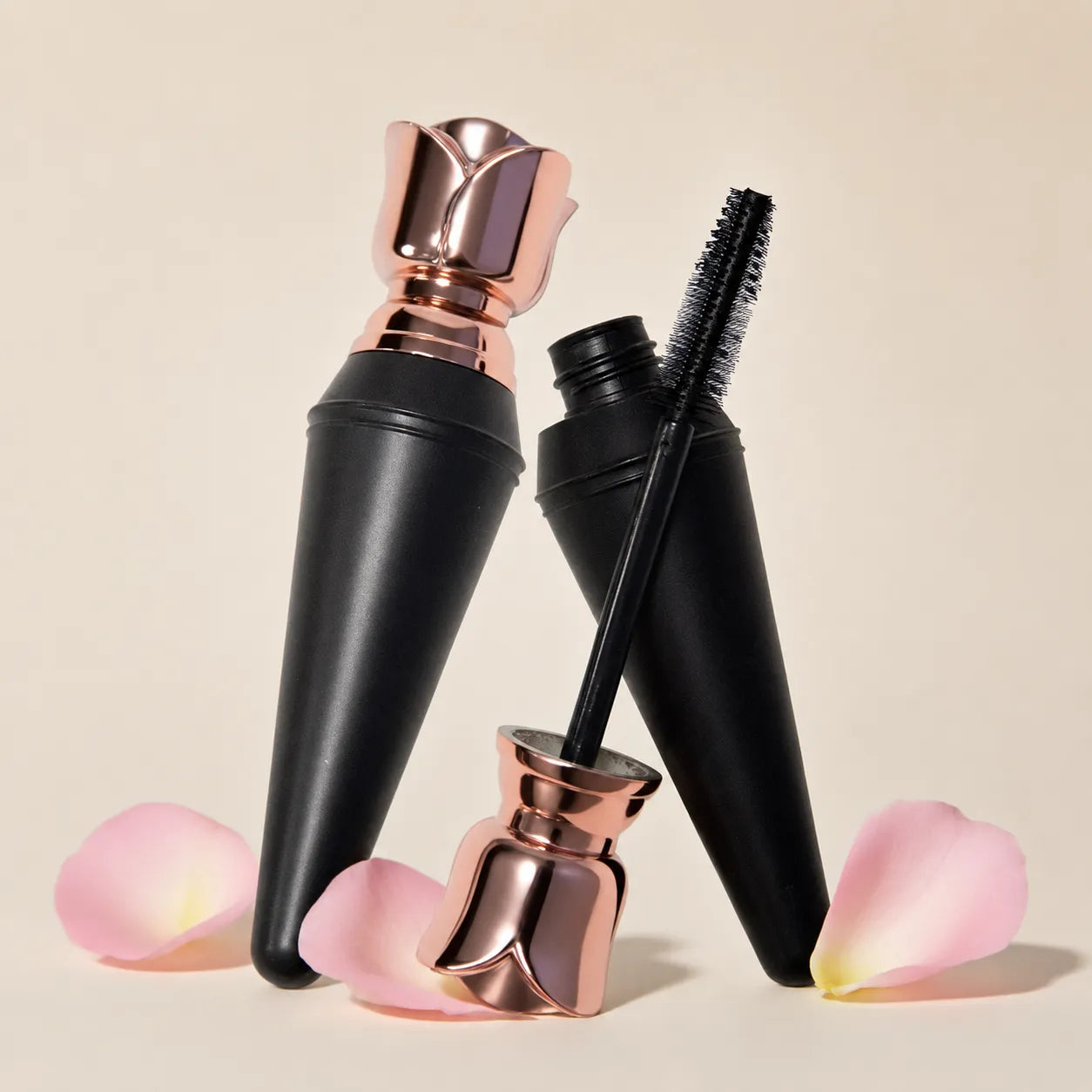 Matte black cosmetic packaging featuring a black mascara tube with wand applicator and rose gold cap by Kaiya