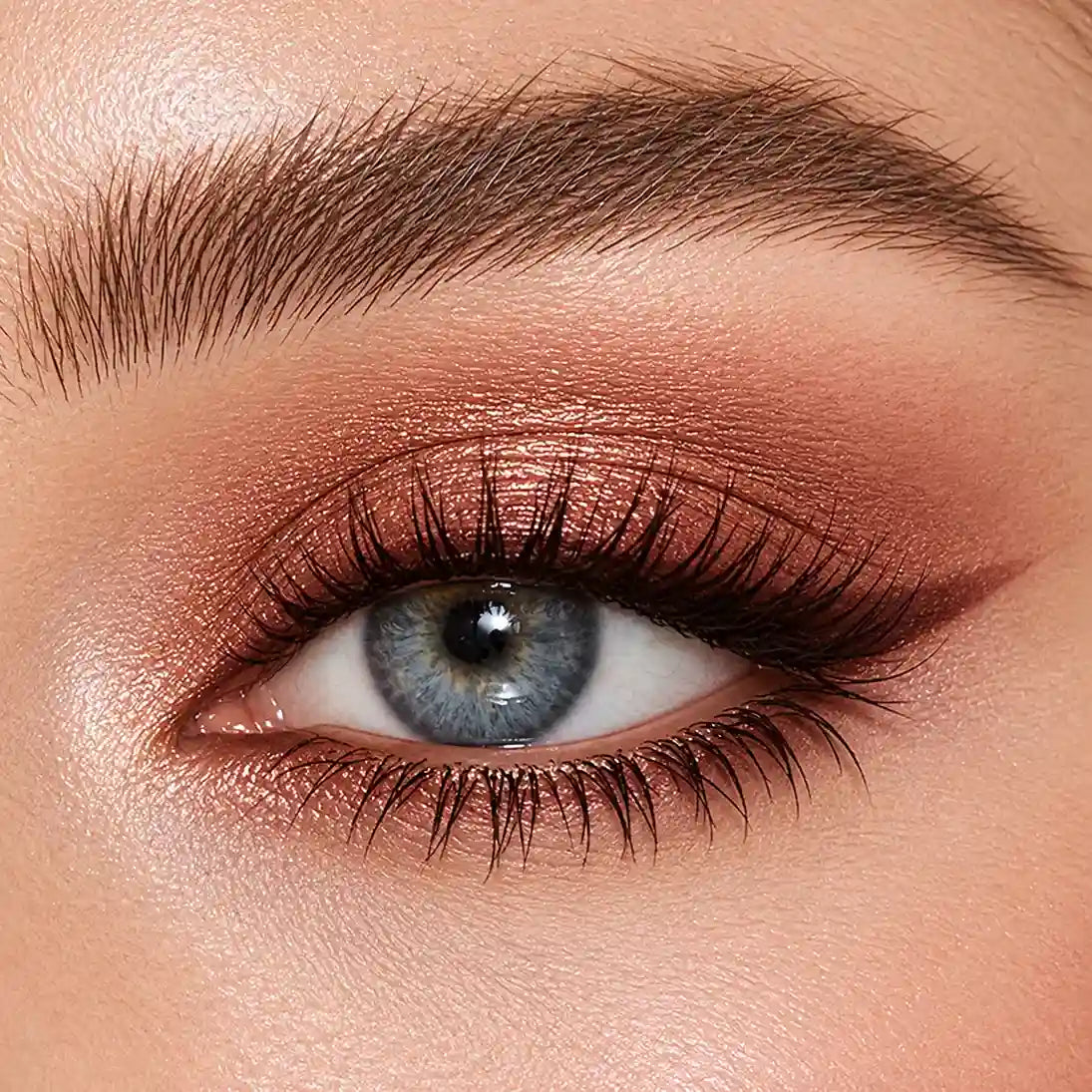 KAIYA eyeshadow color payoff example showing rich copper shimmer on the eyelid with deeper brown crease definition.
