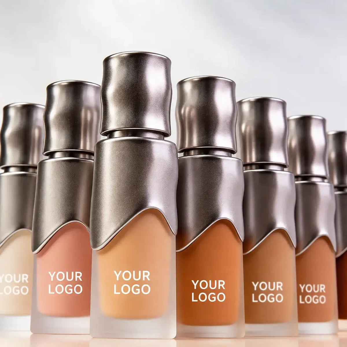 Private label concealer bulk supply with multiple skin-tone shades in matching silver cosmetic containers for beauty brands.