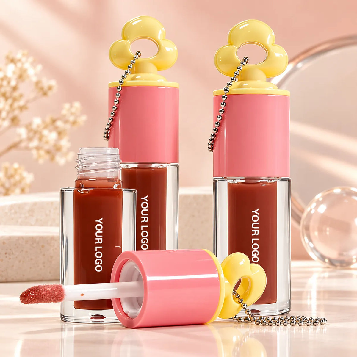 Private label lip oil tubes with doe-foot applicators, pink caps and flower charms