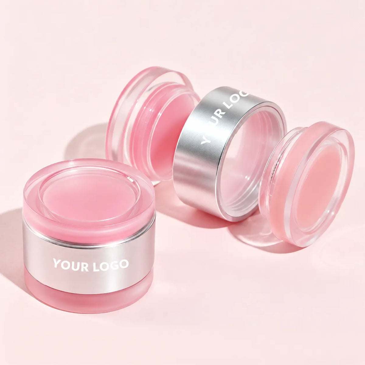 Open pink private label lip scrub jars with clear lids and silver bands
