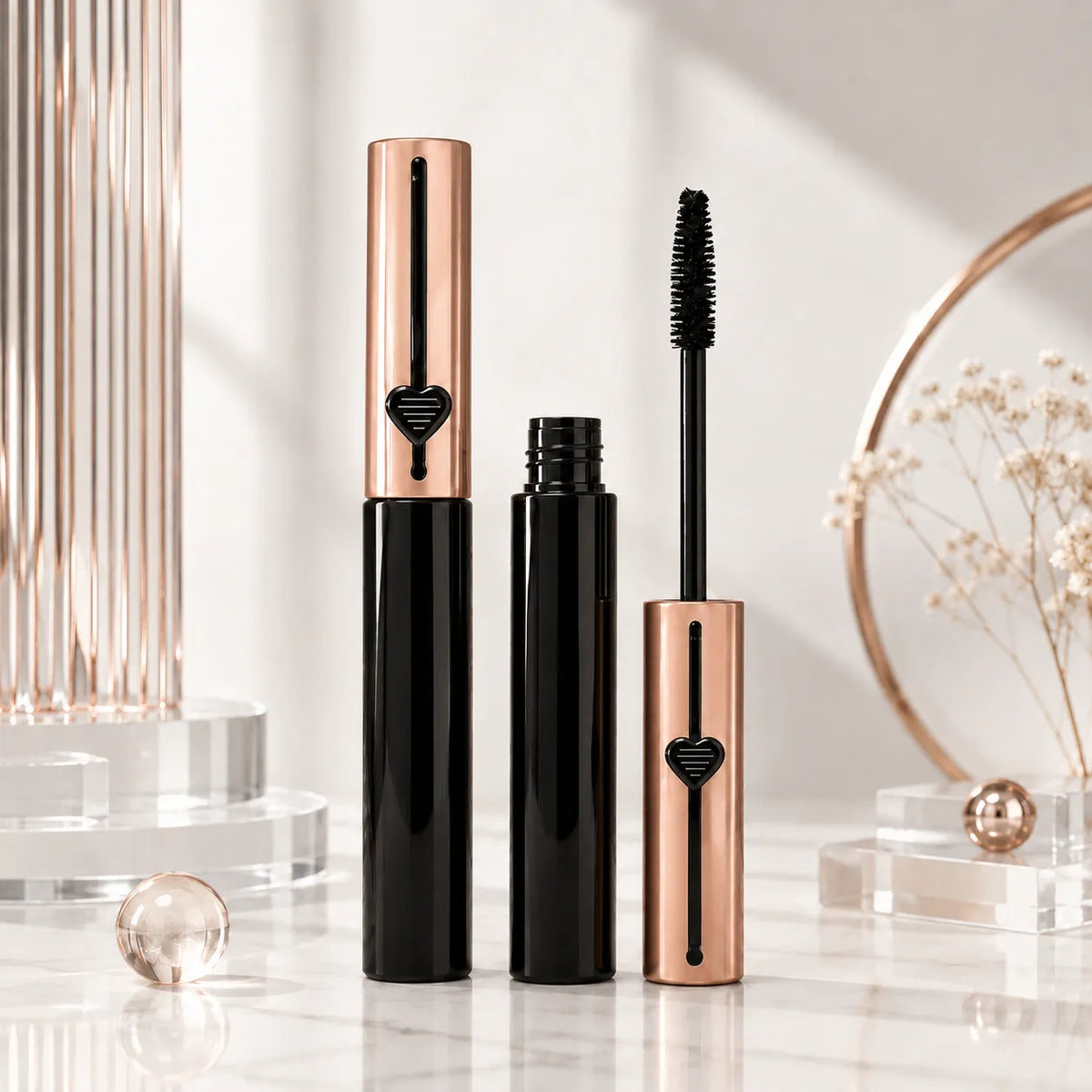 Mascara packaging rose design with black tube body, rose gold cap details, matching applicator, and decorative heart-shaped accent