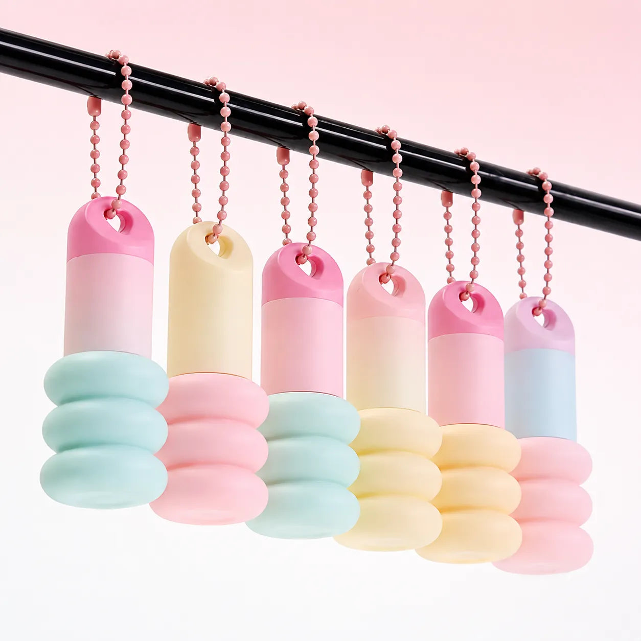 Cute lip tint packaging in pastel hanging keychain style with capsule-shaped mini containers