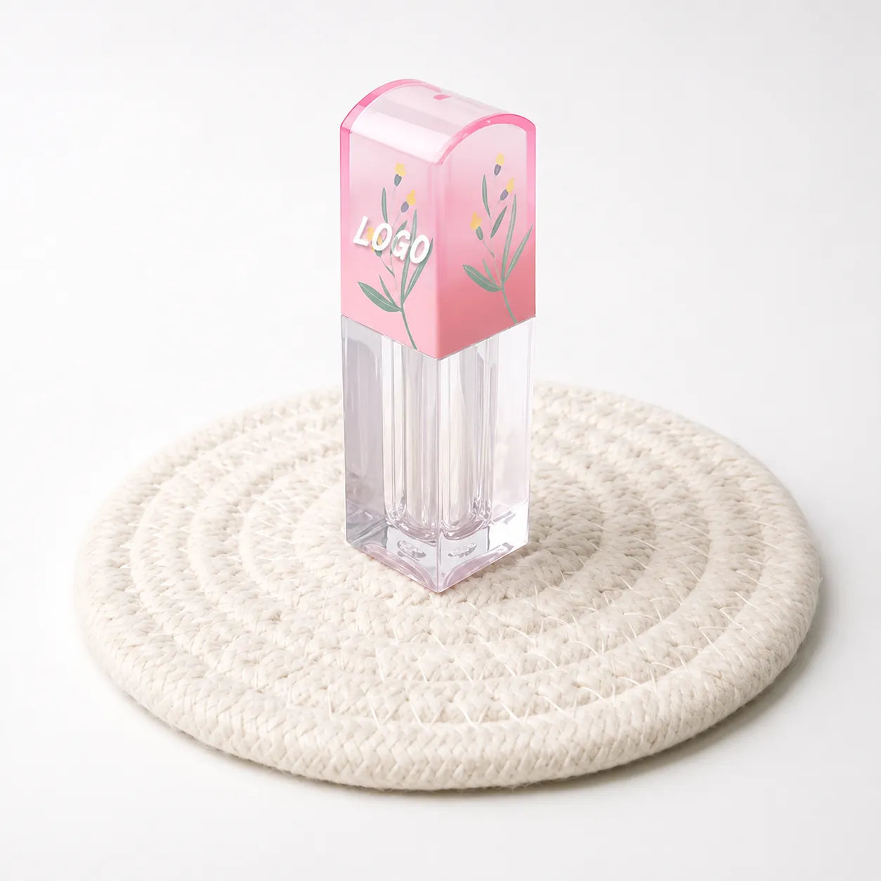 Empty square lip gloss tubes with pink floral caps and clear bodies for Kaiya custom lip gloss packaging.