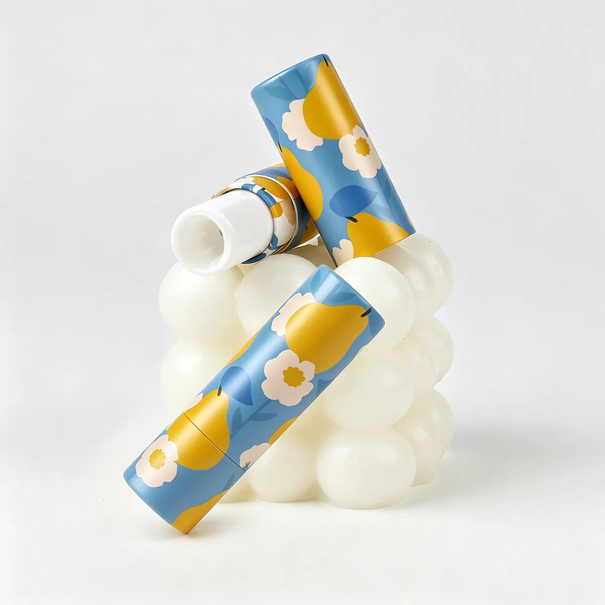 Kaiya cardboard lip balm containers with floral printed design for custom lip care packaging.