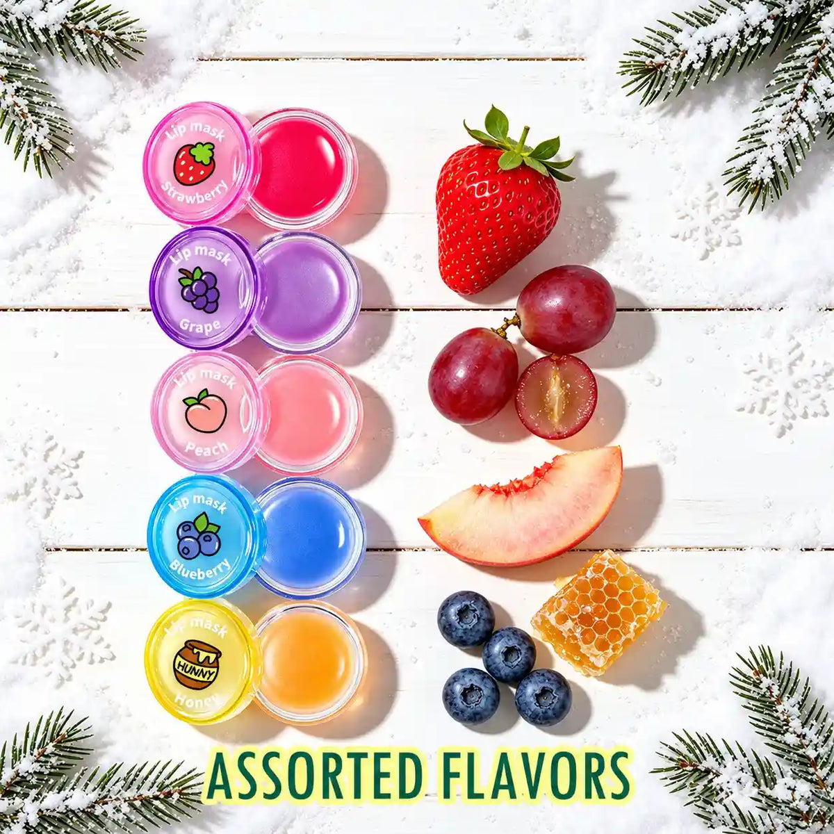 Five lip mask pots labeled strawberry, grape, peach, blueberry and honey beside matching flavor-themed props.