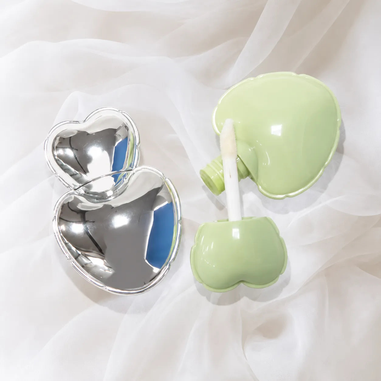 Kaiya heart shaped lip gloss tubes and cute lip gloss bottles in green and silver packaging.