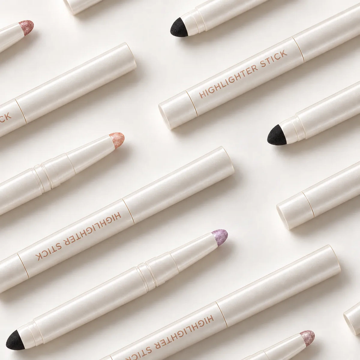 Highlighter pens in white containers with exposed pearl-colored tips and matching caps.