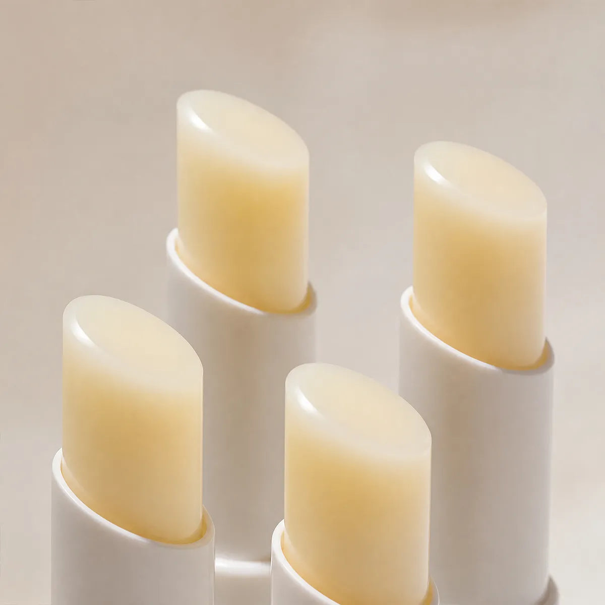 Four translucent lip balm bullets showing consistent shape, smooth surfaces and solid bullet structure.