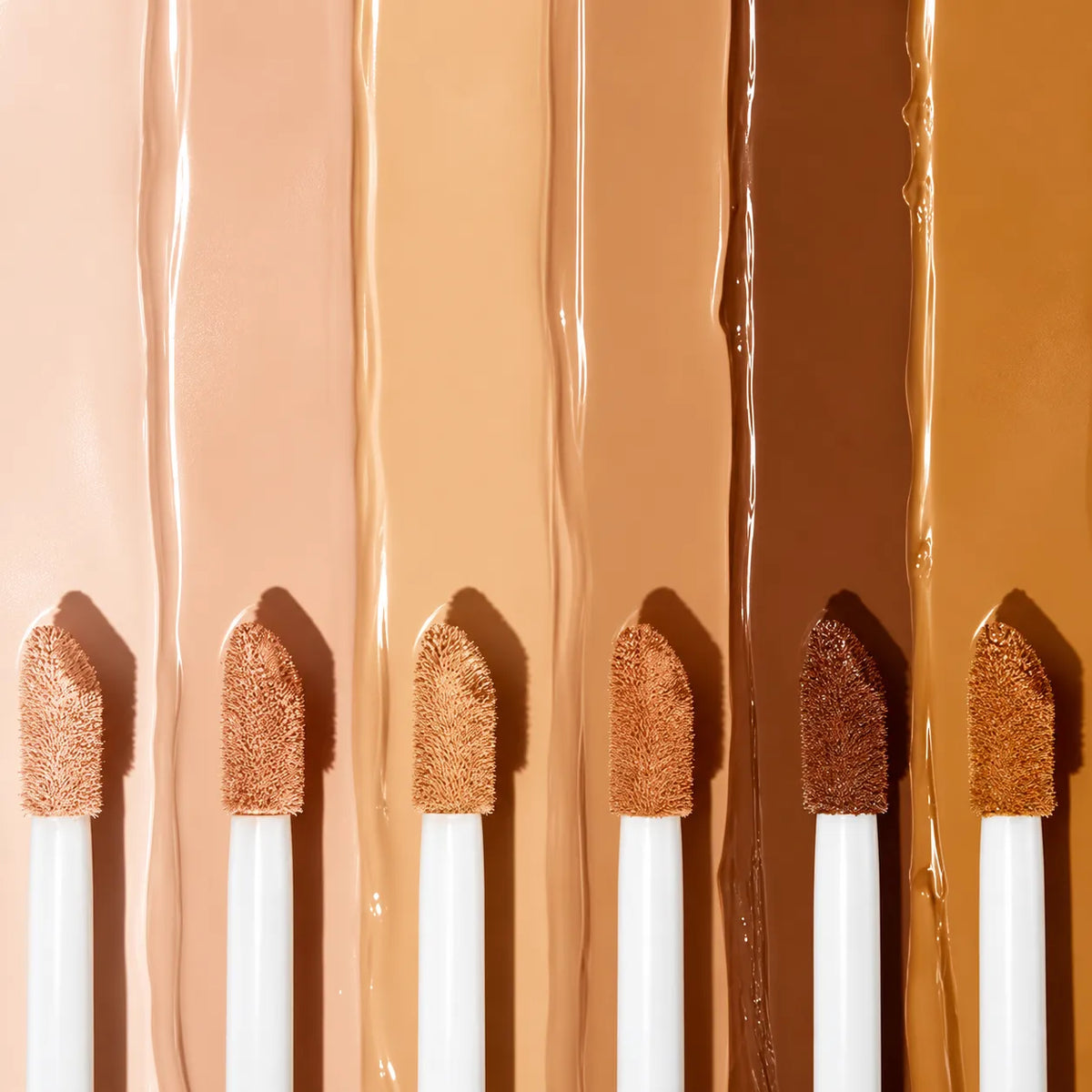 Liquid concealer shades with soft applicator brushes and creamy textures for smooth blending and even application.