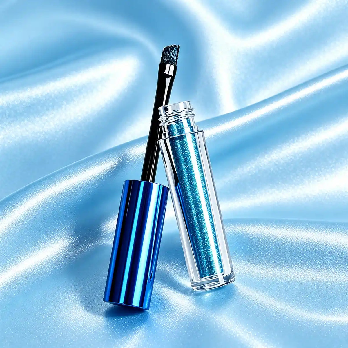 KAIYA liquid eyeshadow container with a clear cylindrical body, metallic blue cap and built-in brush applicator.