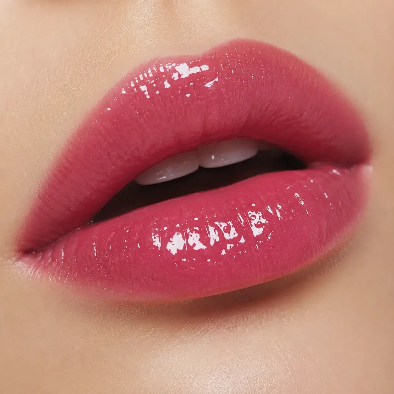 Pink liquid lipstick showing even color coverage and a smooth reflective finish on the lips