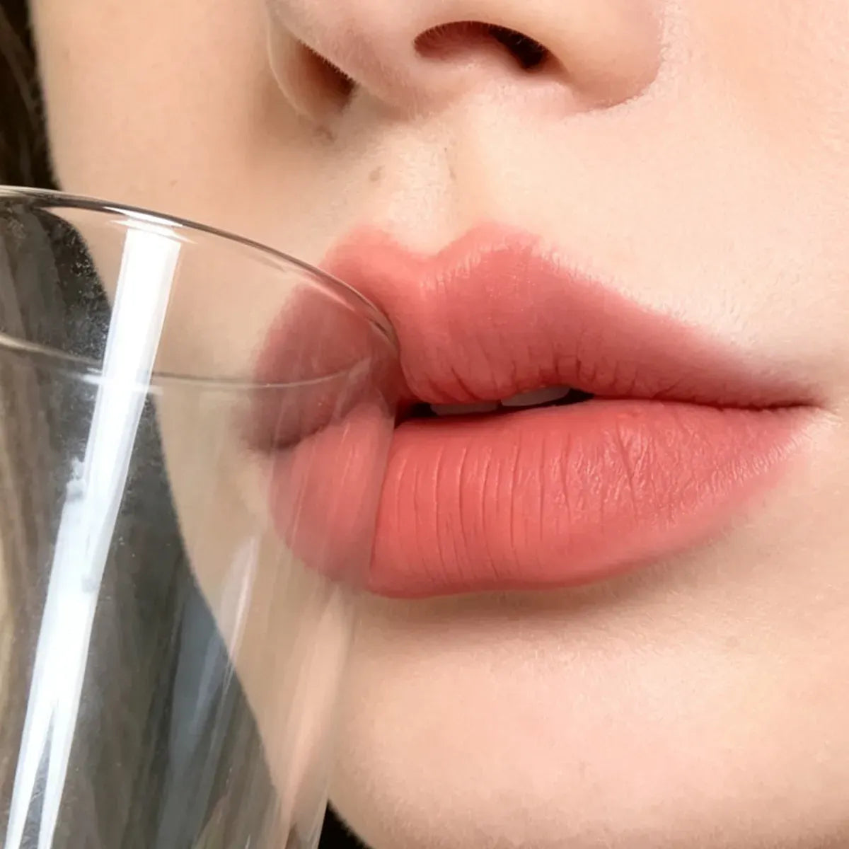 KAIYA non-transfer lipstick in a soft matte nude shade shown beside a drinking glass