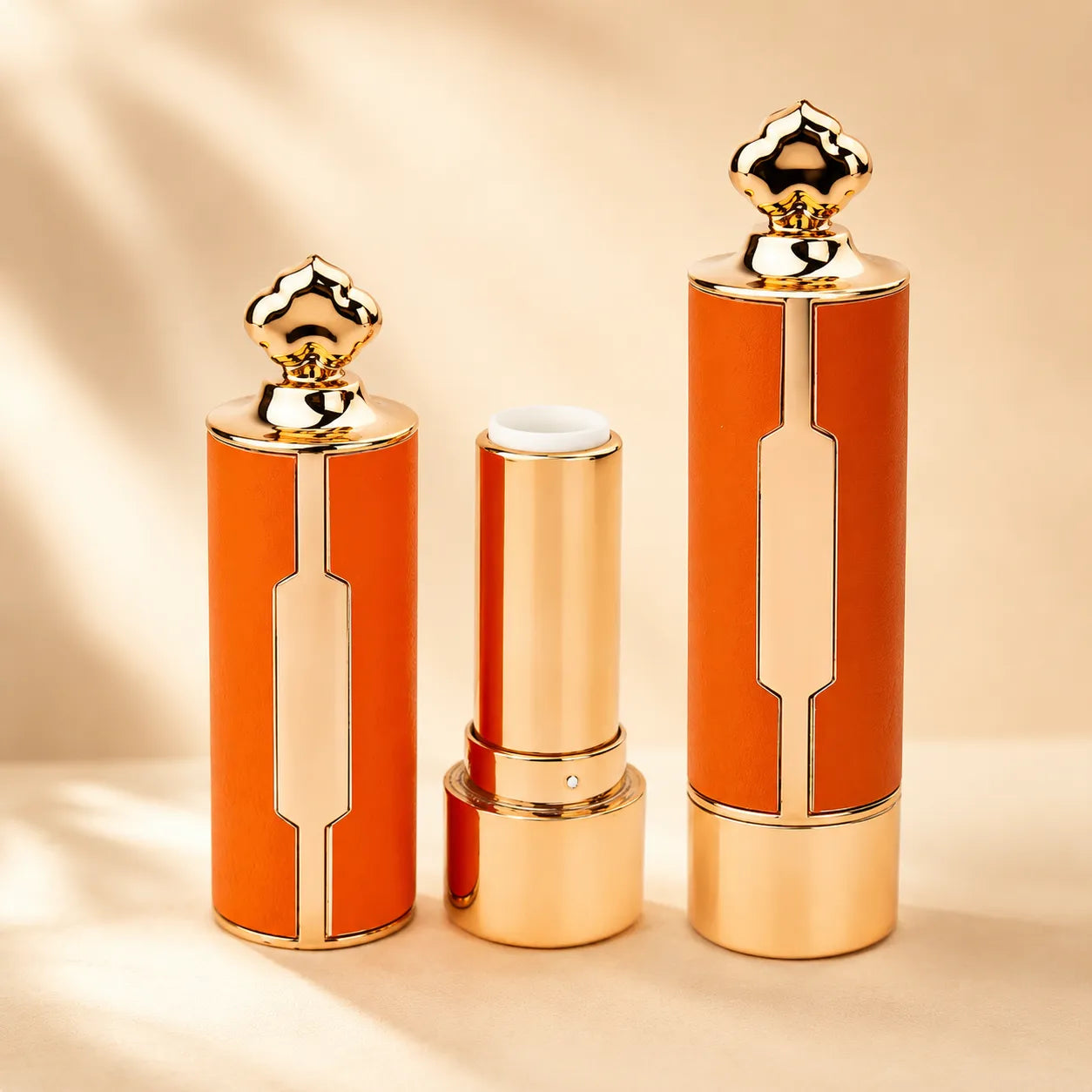 Gold lip balm containers with orange body and metallic gold finish, featuring a luxury decorative cap and refill-style inner tube for custom lip balm packaging.