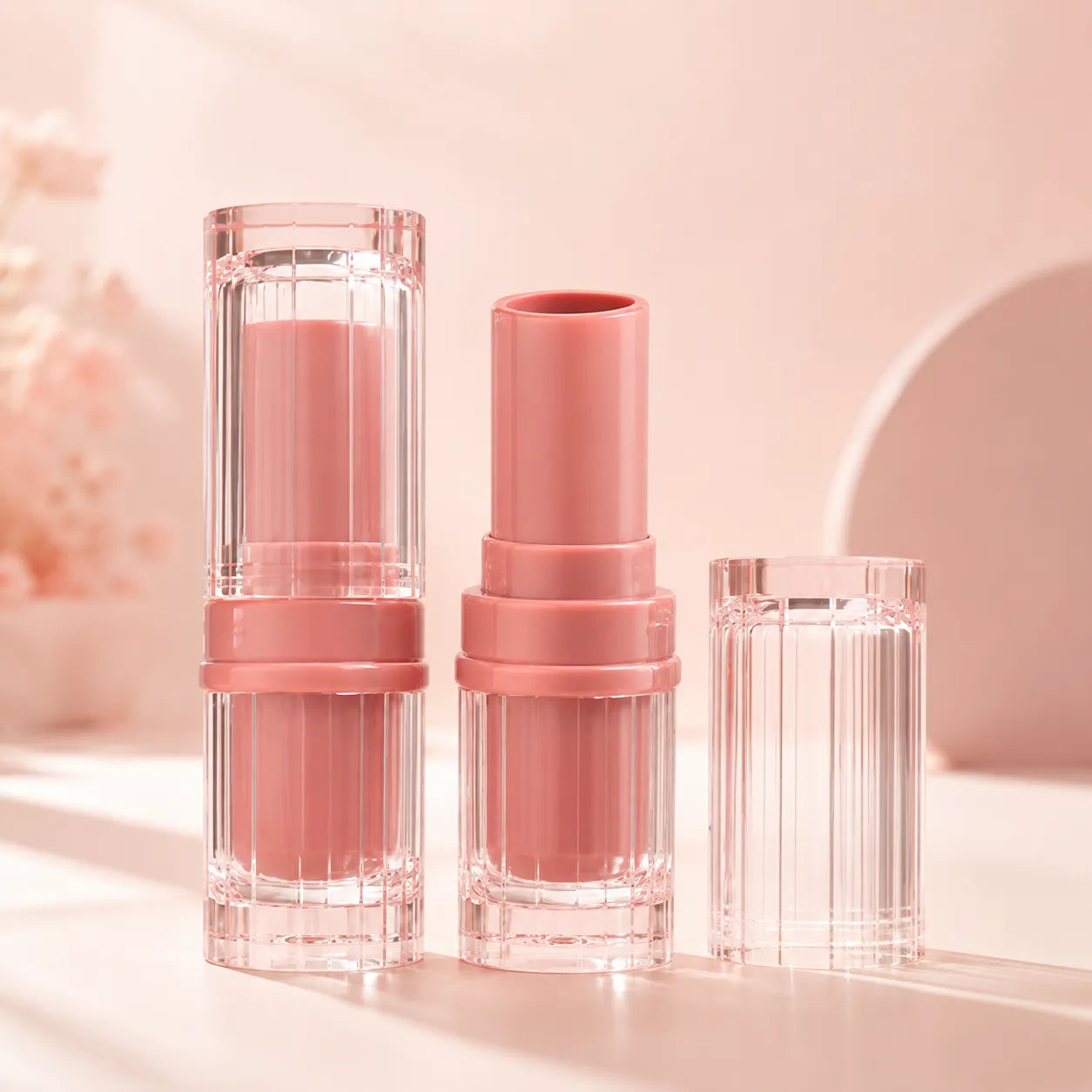 Kaiya pink lip balm containers with clear square outer cases and soft pink twist-up tubes for custom lip balm packaging.