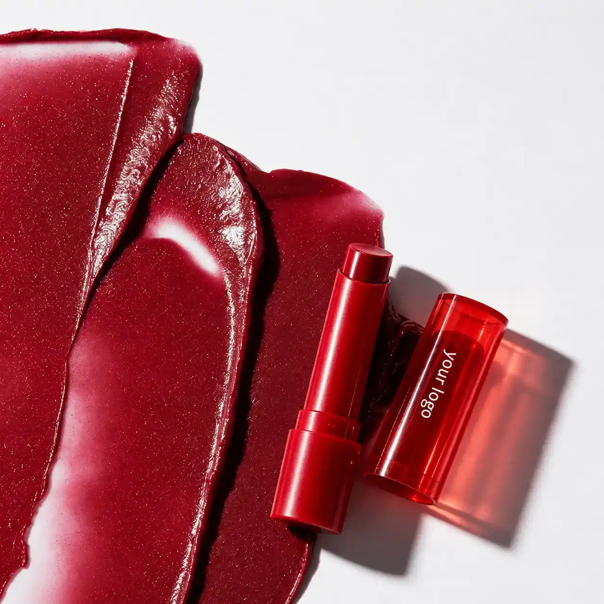 Red tinted lip balm bullets and swatches showing rich color payoff and a glossy special-effect finish.