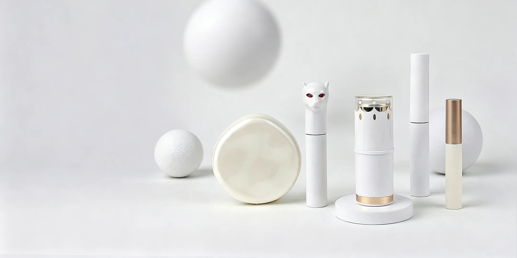 Kaiya white cosmetic packaging collection with clean metallic details for lip gloss, mascara, eyeliner, and decorative makeup components.